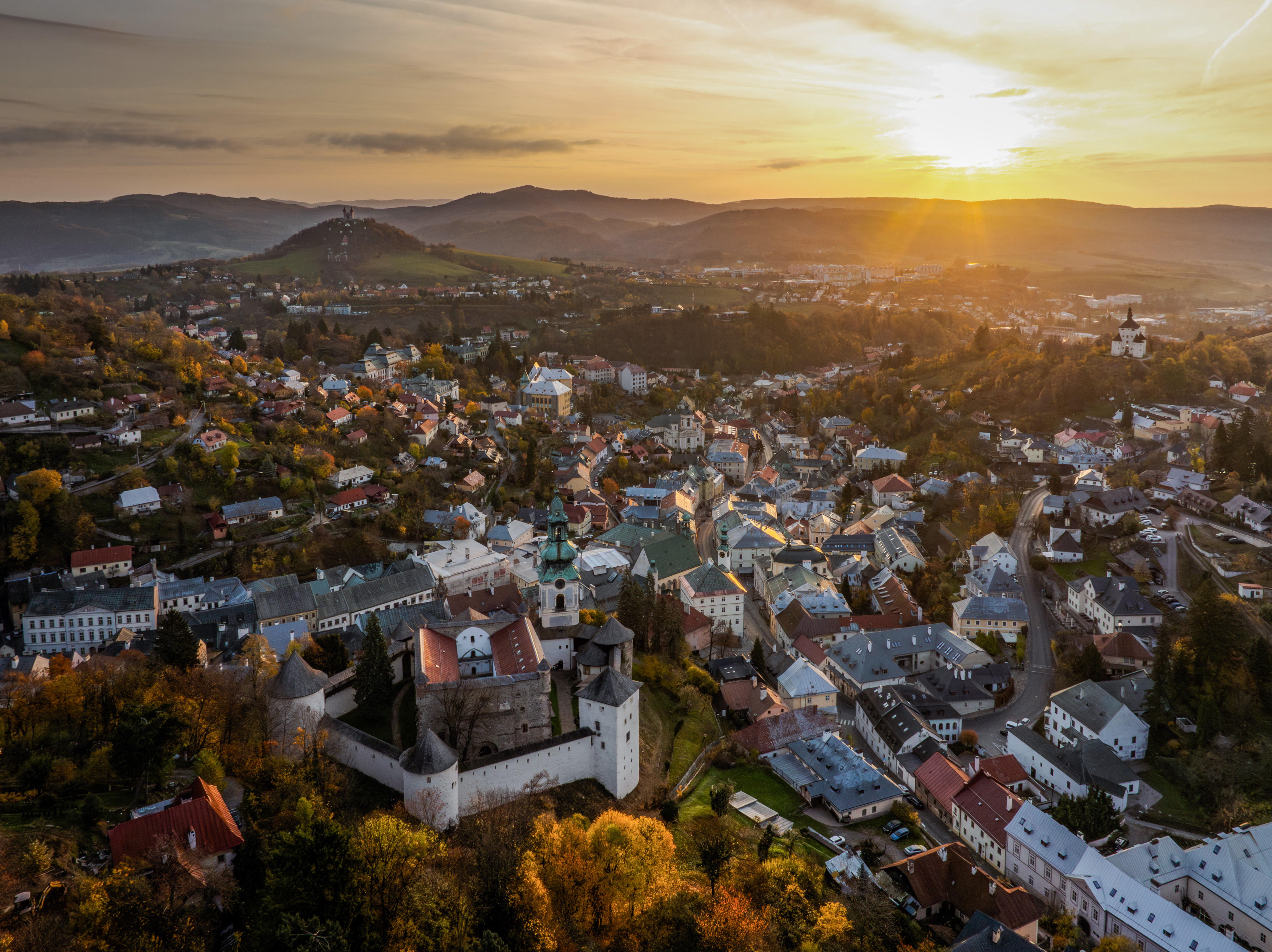 Východ slnka nad historickým centrom Banskej Štiavnice, letecký pohľad so Starým zámkom