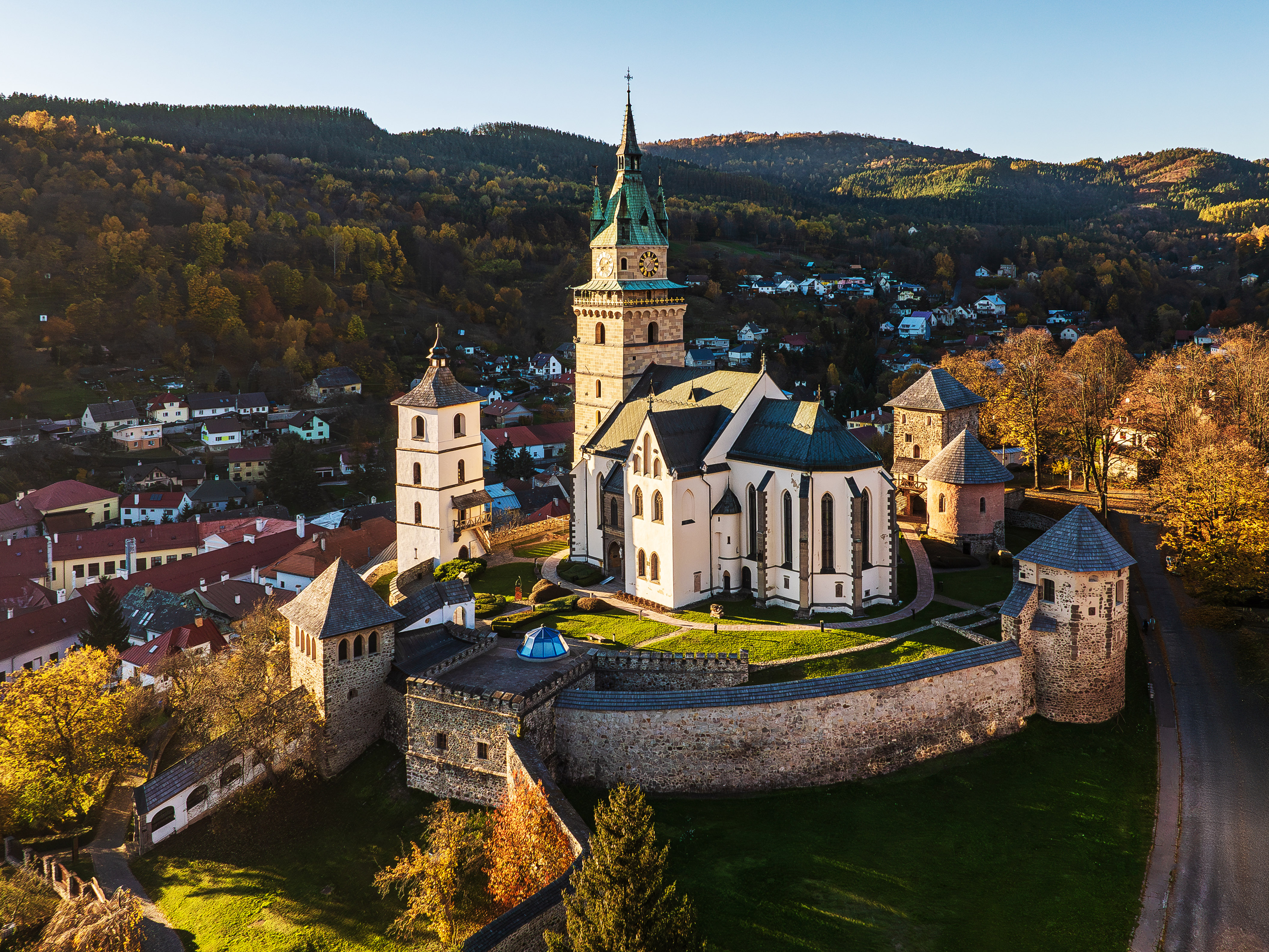 Kostol svätej Kataríny v Kremnici s historickým opevnením, pohľad z drona na jesenné mesto