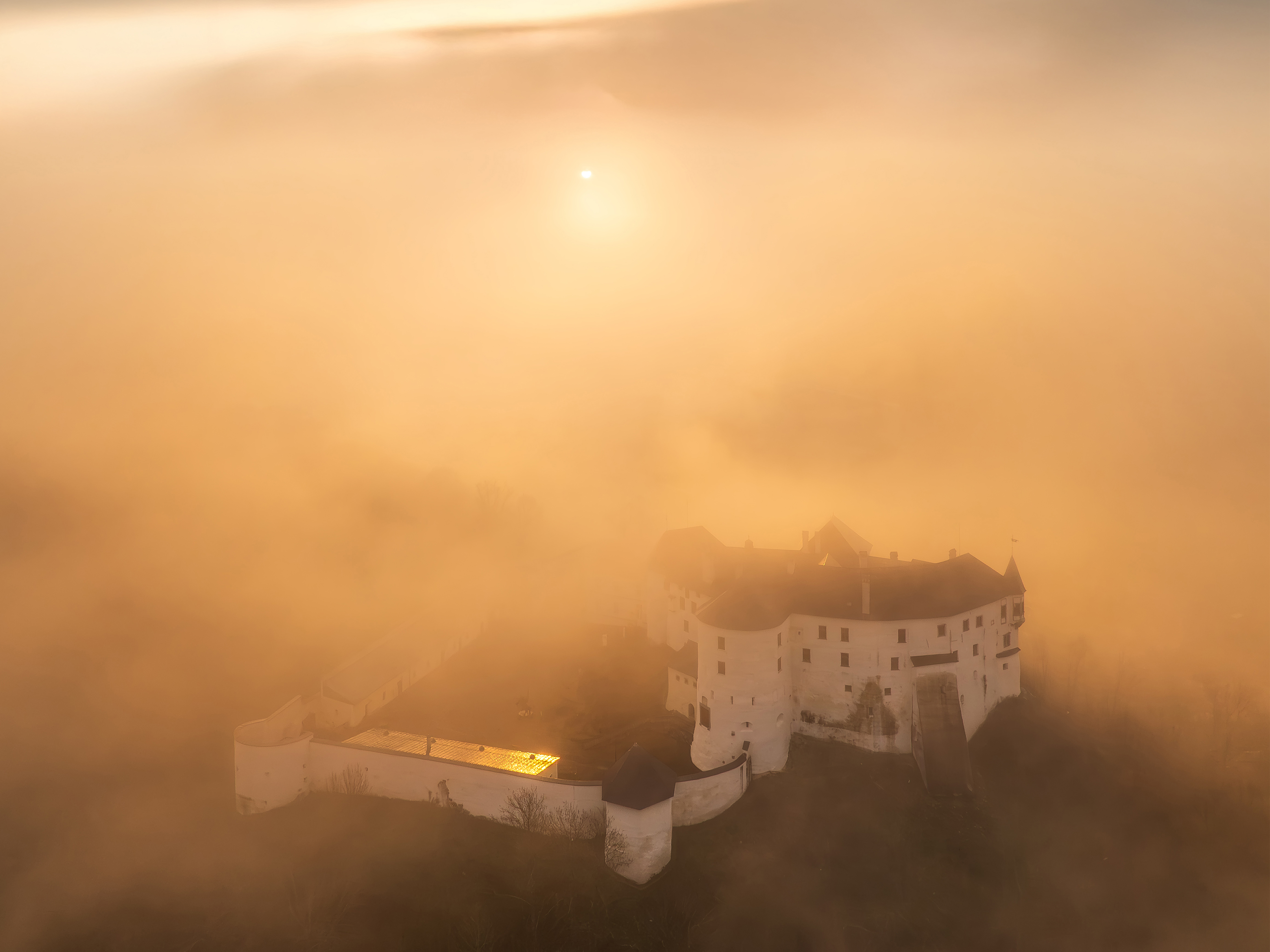 Hrad Ľupča zahalený rannou hmlou – letecká fotografia pri východe slnka